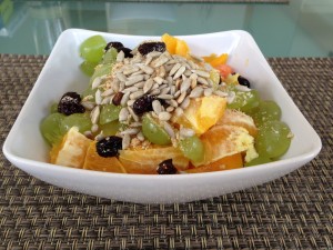 Basisches Müsli mit Mango, Trauben, Orangen, Cranberries und gerösteten Sonnenblumenkernen