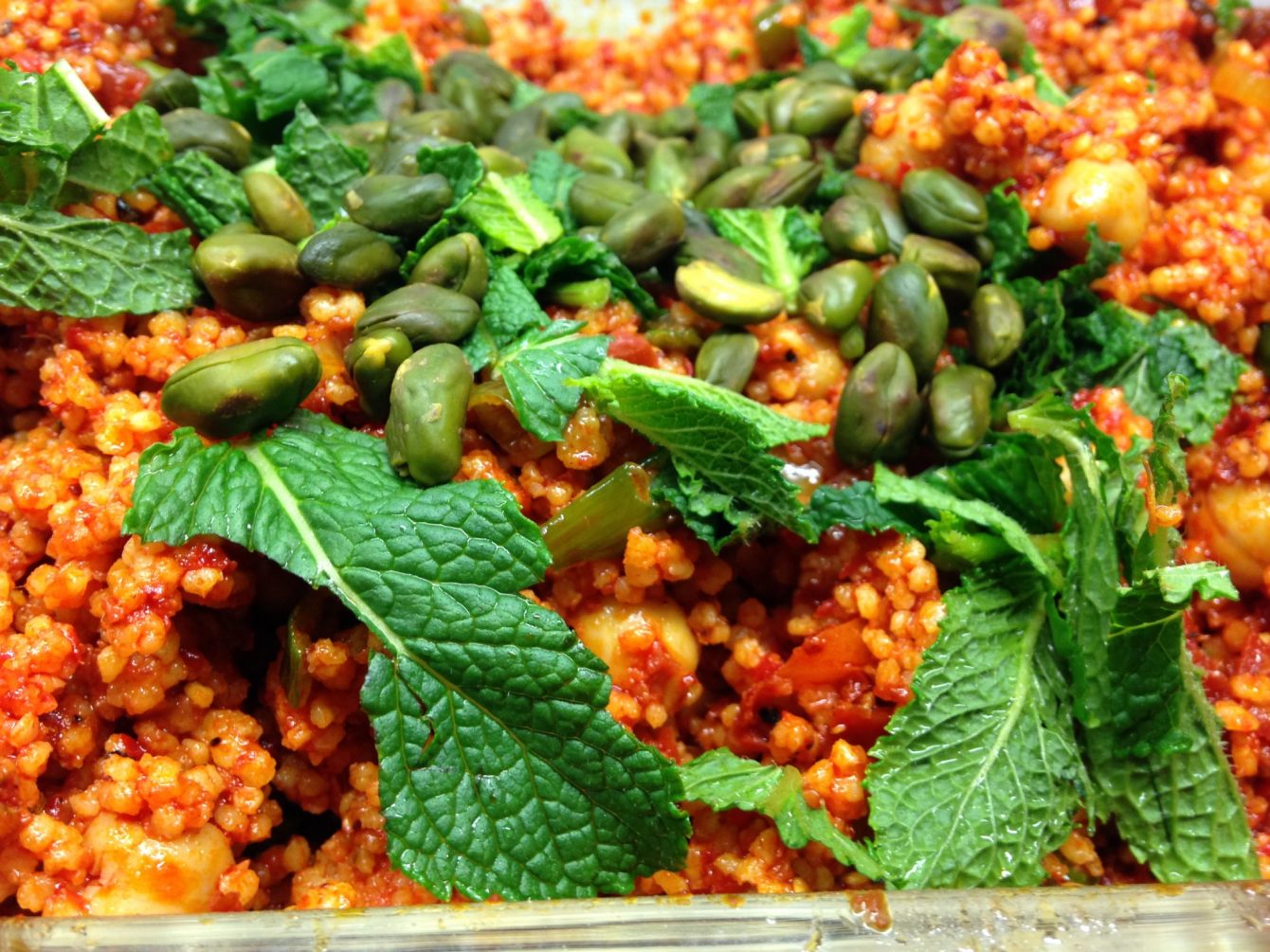 Gewürzhirse Taboulé mit Frühlingszwiebeln, Kichererbsen, Rosinen, getrockneten Tomaten, Pistazien und Minze
