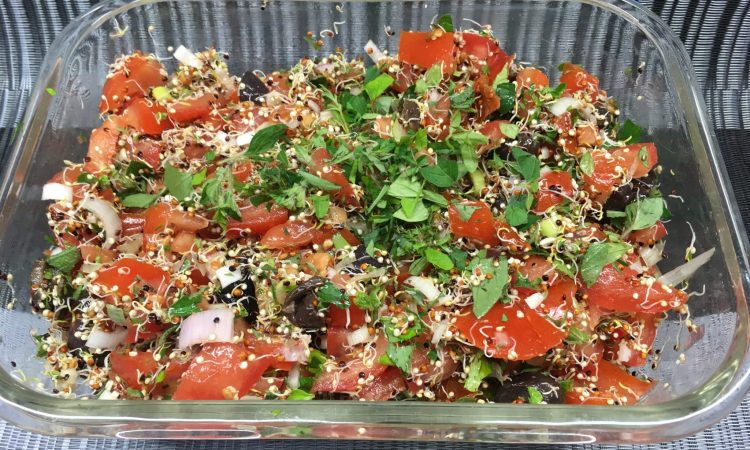 Tomatensalat mit schwarzen Oliven, Quinoa Sprossen und Pesto Dressing