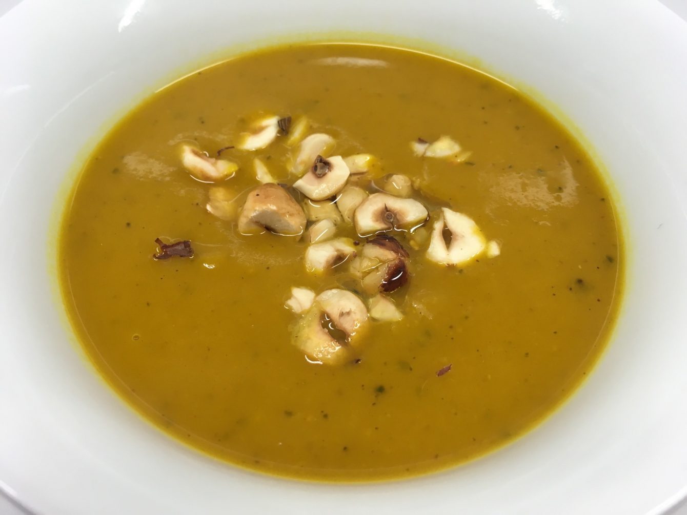 Kürbissuppe mit Äpfeln und gerösteten Haselnüssen