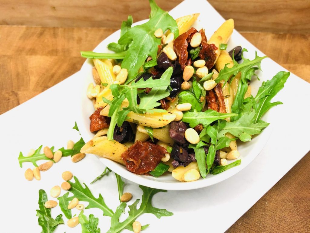 Nudelsalat mit Tomaten, Oliven, Rucola und Pinienkernen