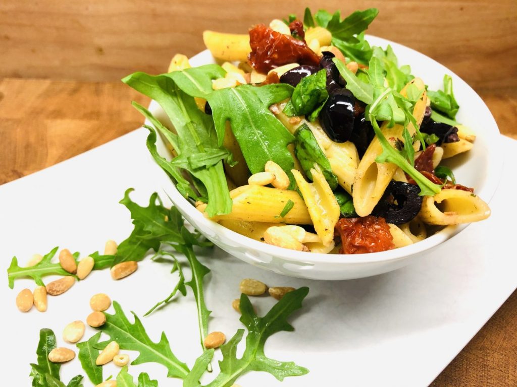 Nudelsalat mit Tomaten, Oliven, Rucola und Pinienkernen