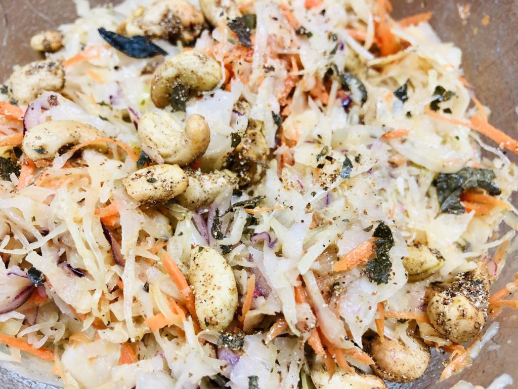 Krautsalat mit Weißkohl, Karotten, gewürzten Cashewkernen und Limetten-Mohn-Dressing