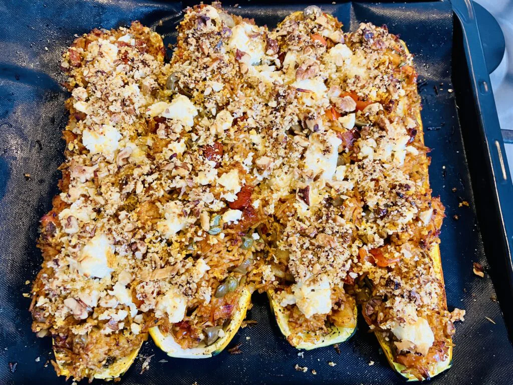 Gefüllte Zucchini mit würzigem Tomatenreis, Feta, Oliven & knusprigem Zitronen-Crunch